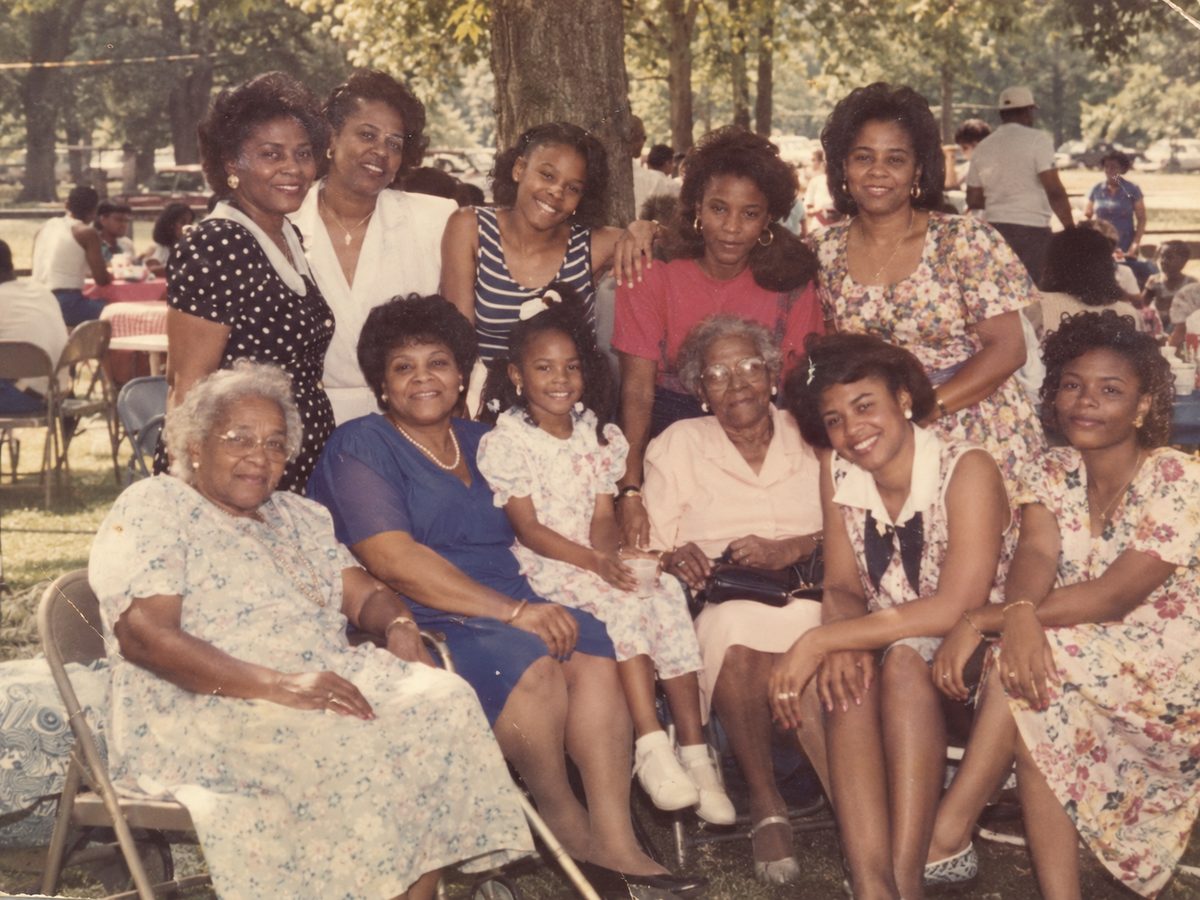 Several generations of women from one family gathered together at an outdoor picnic.